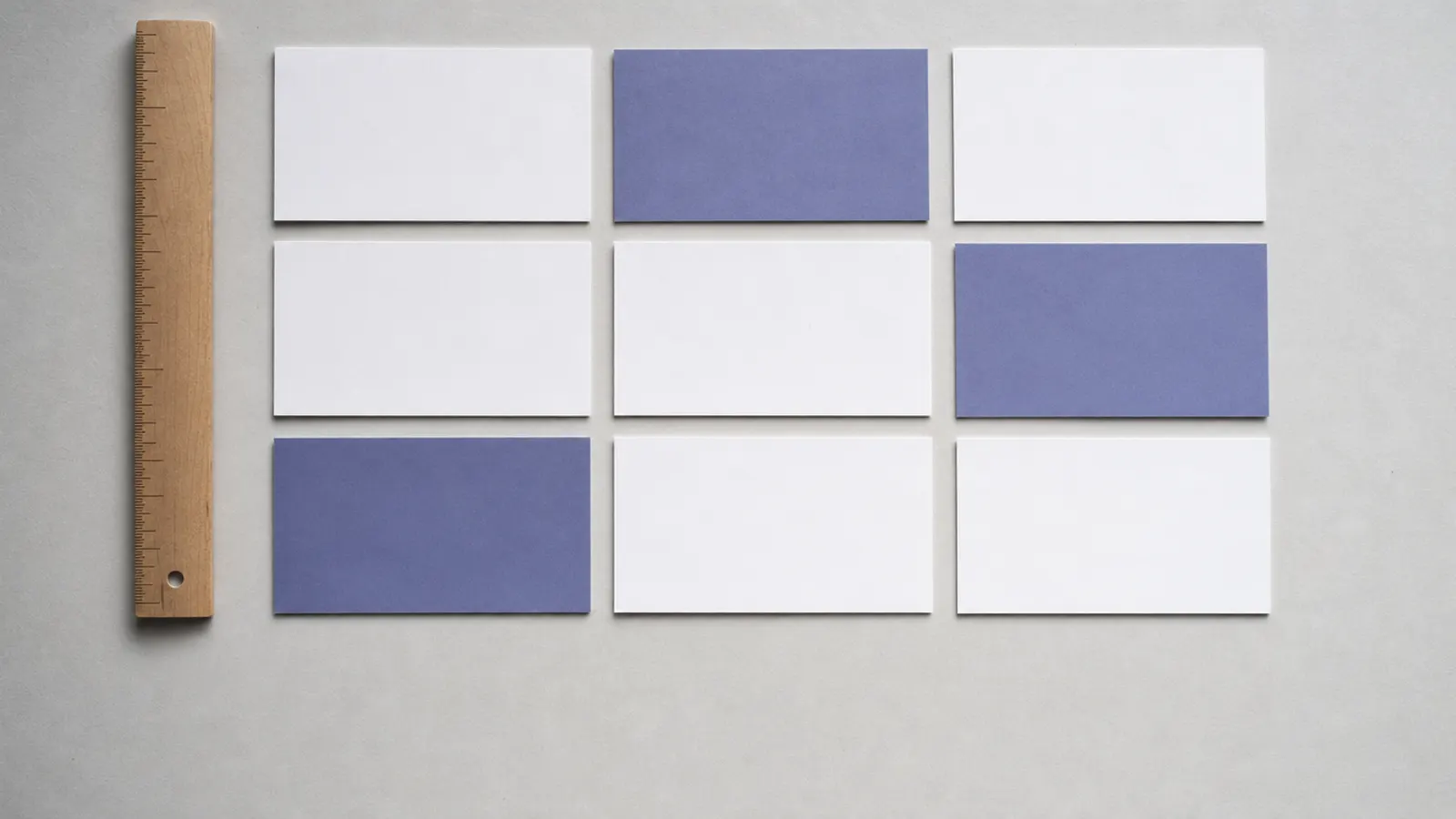 Blank index cards arranged in a grid on grey paper