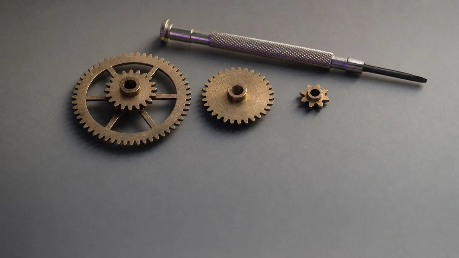 A precision screwdriver and brass gears — fine-tuning